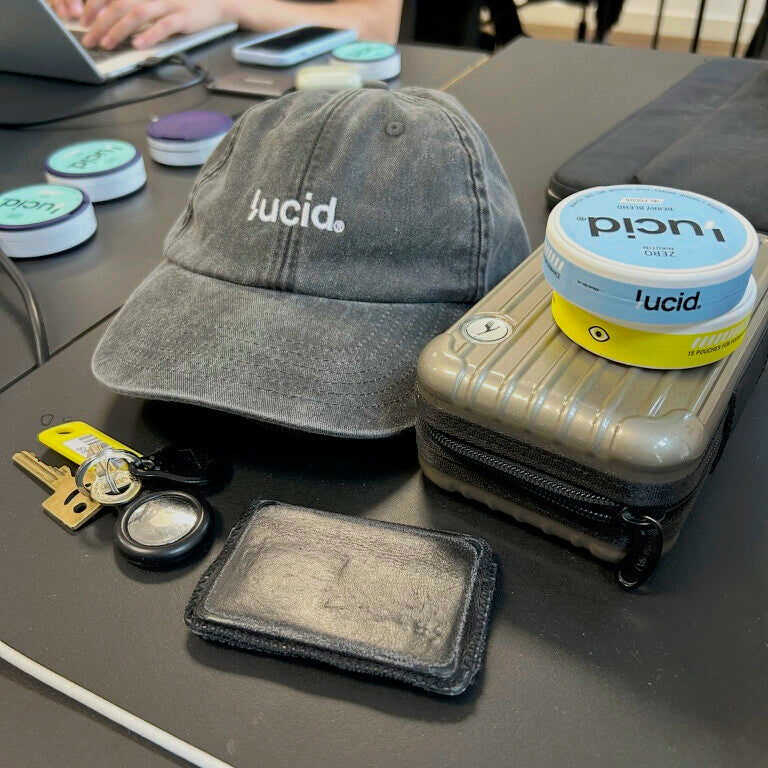 lucid® Cap in Grau auf einem Schreibtisch neben lucid® Focus Pouches