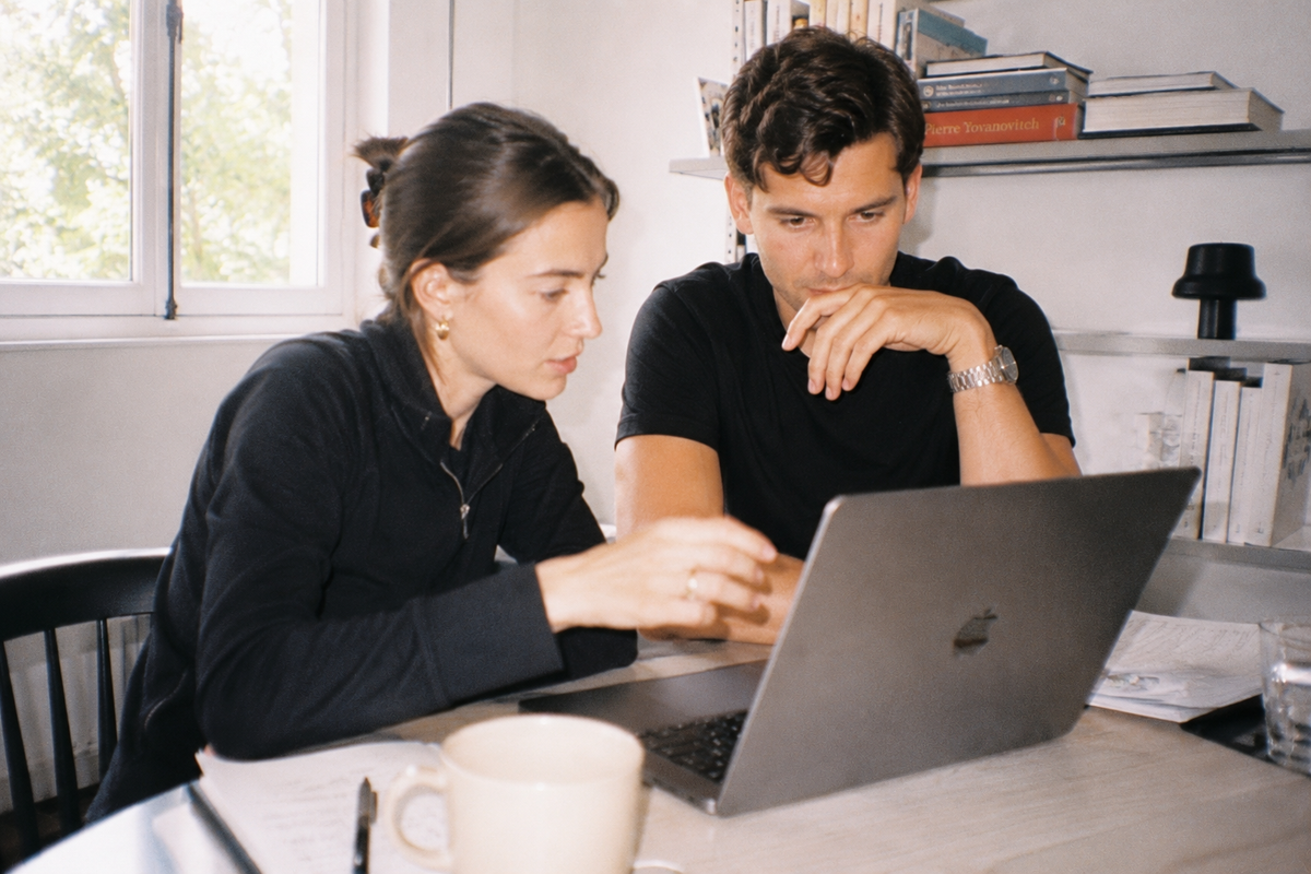 Zwei Menschen konzentriert bei der Arbeit am Laptop